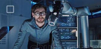 Persona codificando en una computadora portátil, flanqueada por dos monitores que muestran códigos coloridos.